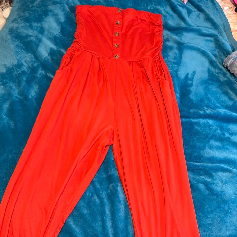 Embrace vibrant charm in this tangerine romper with delightful button details!